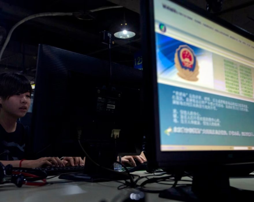 Computer users sit near a monitor display with a message from the Chinese police on the proper use of the Internet at an Internet cafe in Beijing, China. (Photo: AFP/VOA)