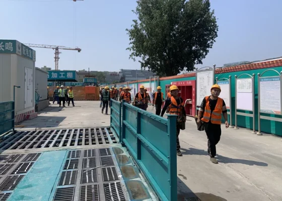 Construction workers in Beijing walk out of a site during their noon break. (Photo: Aowen Cao/NPR)