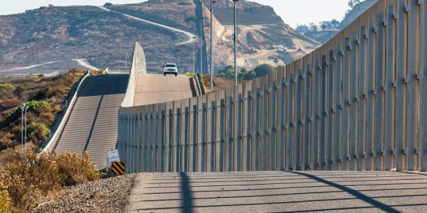 The international border wall between San Diego, California and Tijuana, Mexico, with an approaching U.S. Border Patrol vehicle on a nearby hill. (Photo:D©Sherryvsmith/Dreamstime.com9