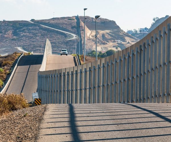 The international border wall between San Diego, California and Tijuana, Mexico, with an approaching U.S. Border Patrol vehicle on a nearby hill. (Photo:D©Sherryvsmith/Dreamstime.com9