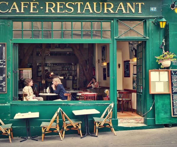 Two women sitting on open terrace in typical Parisian cafe. Restaurants, bars and coffee shops on sidewalks are very popular with parisians and tourists visiting Paris. (Photo:© Rostislav Glinsky | Dreamstime.com)