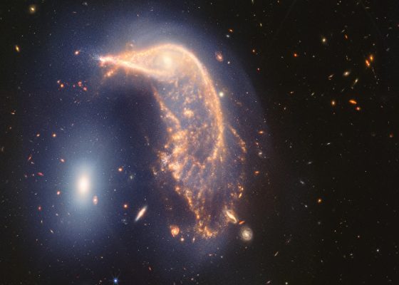 The distorted spiral galaxy at the centre, the Penguin, and the compact elliptical galaxy at the left, the Egg, are locked in an active embrace. A new near- and mid-infrared image from the James Webb Space Telescope, taken to mark its second year of science, shows that their interaction is marked by a faint upside-down U-shaped blue glow. (Photo: NASA, ESA, CSA, STScI)